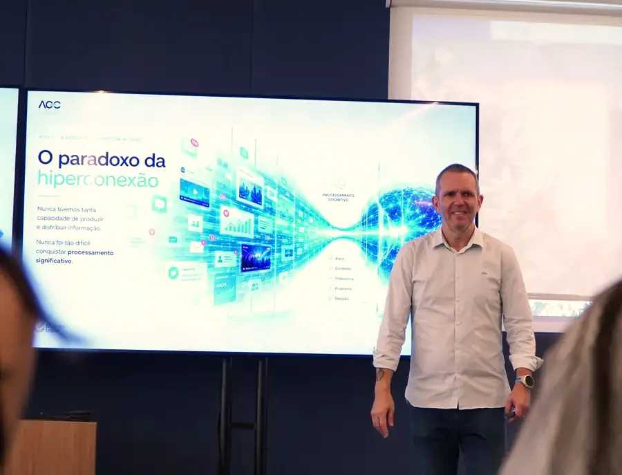 Evandro Lopes diante de uma tela com o slide do paradoxo da hiperconexão, durante uma sessão